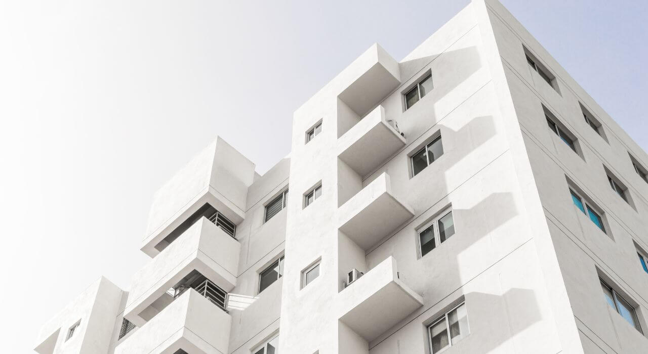 fachada de um prédio branco de apartamentos
