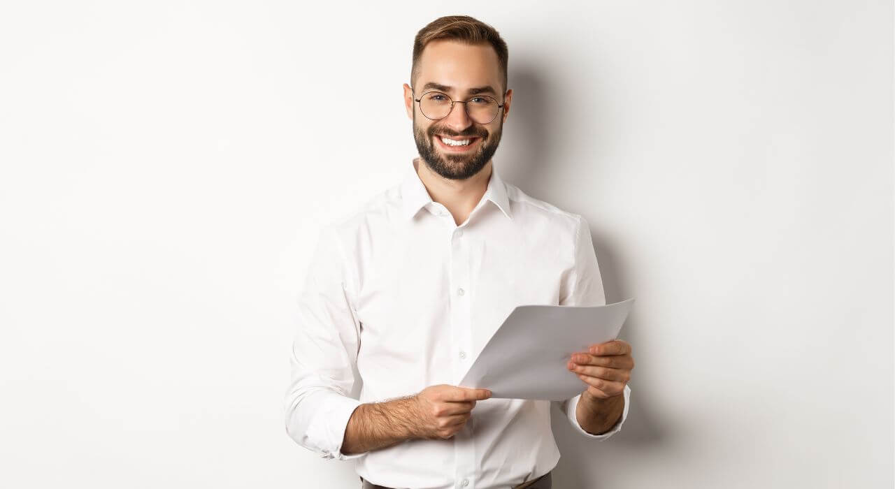homem de camisa branca segurando uma folha de documentos